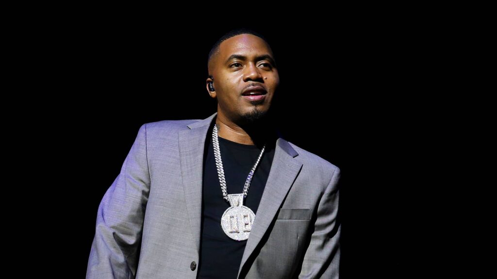 A black man putting on a gray suit with black background